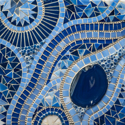 Shades of blue glass, stones, agate, metal and grout on wood