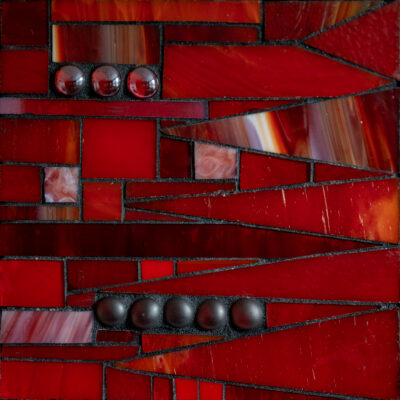 Diffrent shades of red glass and grout on wood