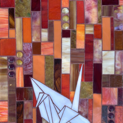 paper crane made out of glass and grout on wood