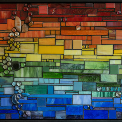 Rainbow glass, stones, and grout on wood