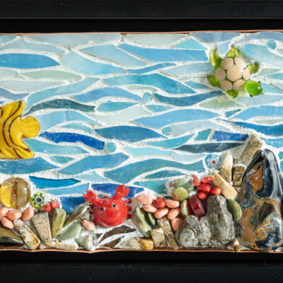 Reef made out of glass, stones, shells, and grout on wood