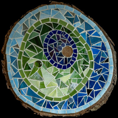 Blue and green and teal glass and grout on wood