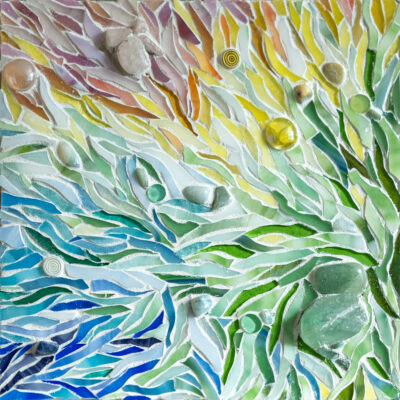 Rainbow colored glass, stones, and grout on wood